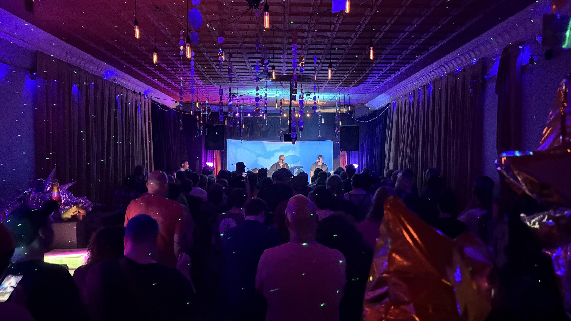 A full-color live performance and crowd at Glow Hall